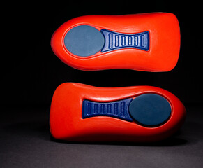 Orthopedic insole on a black background. Treatment and prevention of flat feet and foot diseases