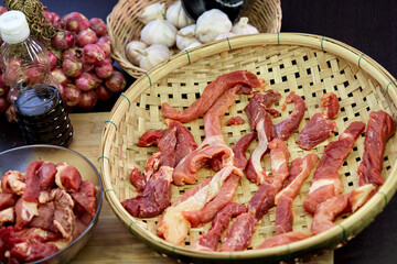 fresh raw meat in the bamboo basket with ingredients for cooking in kitchen