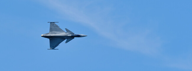 Fototapeta na wymiar Fighter in flight in the sky up side view