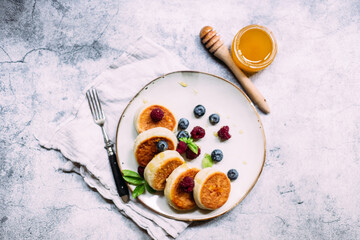 cheesecakes with berries and sauce on a gray background