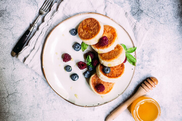 cheesecakes with berries and sauce on a gray background