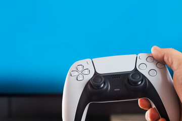 Man holding a Next generation white game controller isolated on blue background. Chroma Key.