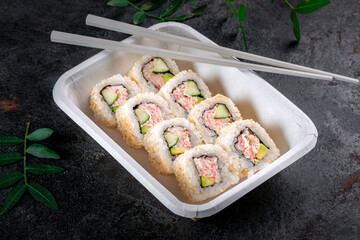 Classic California roll with crab, cucumber and avocado in a delivery box. Japanese cuisine with fresh seafood