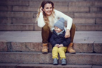 mother and son are walking outdoors on a sunny autumn day