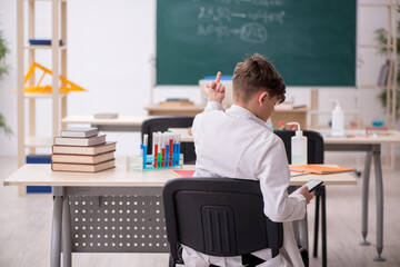 Schoolboy studying chemistry in the classroom