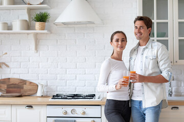 Loving couple in the kitchen with juice, healthy food