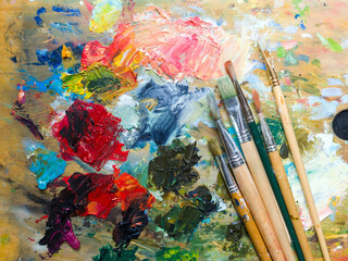 Artist's palette. Oil art paints extruded onto a wooden palette. Tubes and brushes lie on a...