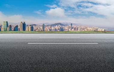 Panoramic skyline and empty asphalt road with modern buildings