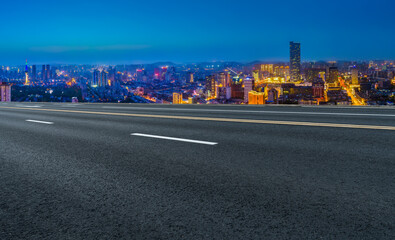 Panoramic skyline and empty asphalt road with modern buildings