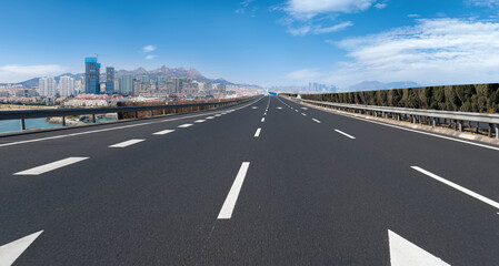 Panoramic skyline and empty asphalt road with modern buildings