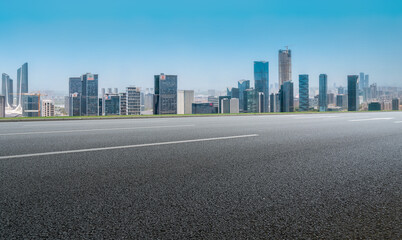 Panoramic skyline and empty asphalt road with modern buildings