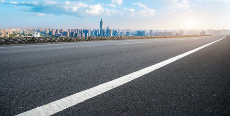 Panoramic skyline and empty asphalt road with modern buildings