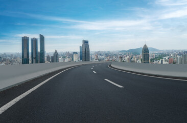 Panoramic skyline and empty asphalt road with modern buildings
