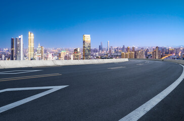 Panoramic skyline and empty asphalt road with modern buildings