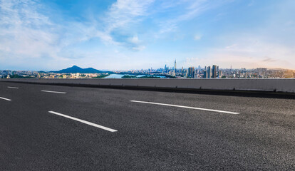 Panoramic skyline and empty asphalt road with modern buildings