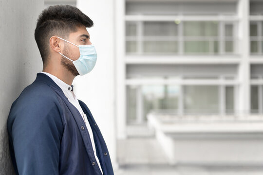 Handsome young man standing outdoors in medical mask. Coronavirus concept. High quality photo