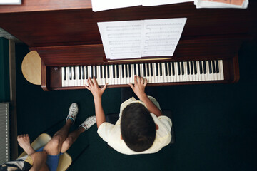Student playing the piano keyboard at piano lesson
