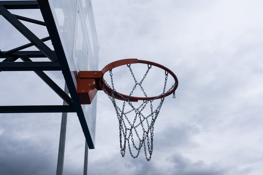 Basketball backboard with a ring, color photo processing. Black and white photo and ring highlighted in red. Focus on the basketball basket as a goal.