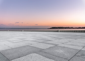 Panoramic skyline and empty square floor tiles with modern buildings