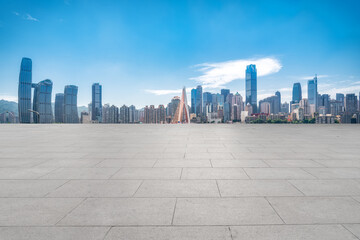 Panoramic skyline and empty square floor tiles with modern buildings