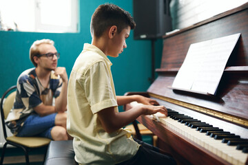 Boy having a piano lesson at music school