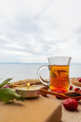 Black tea and rose hips on the background of a cloudy sky