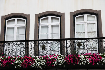 Fototapeta na wymiar Flowered balcony in ancient palace in Angra do Heroismo, Terceira island, Azores