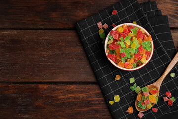 Mix of delicious candied fruits on wooden table, flat lay. Space for text