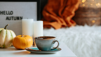 Still-life. A blanket, pumpkins and a cup of tea on the coffee table in the home interior of the...