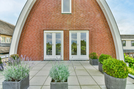 Modern residential house facade against potted plants in suburb