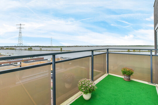 Balcony with potted flowers under cloudy sky - Powered by Adobe