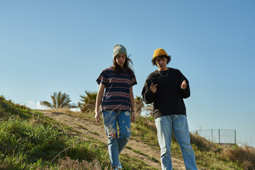 Two captivated young people walking down a hill