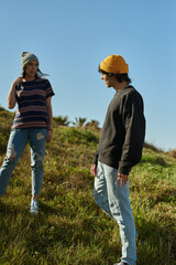 Two engaged young people standing on a hill
