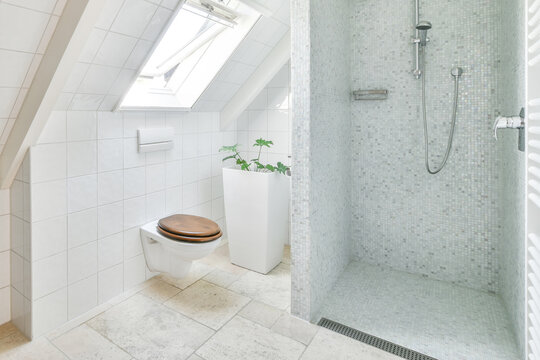 Contemporary bathroom interior with shower room in attic