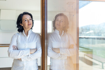 Woman standing near glass door at home