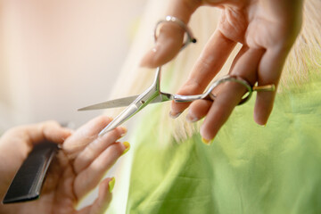 Obraz premium Hands of hairdresser at work in female beauty salon