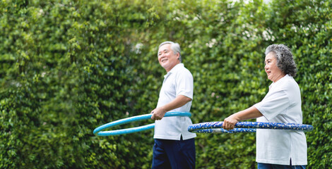 Asian Grandmother and Grandfather exercising with hula hoops