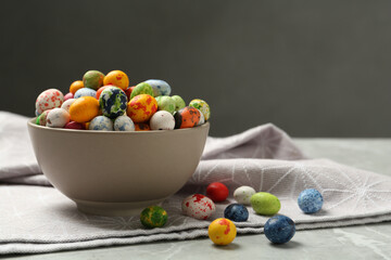 Ceramic bowl with delicious candies on grey table, space for text. Cooking utensil
