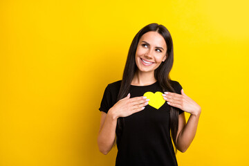 Portrait of pretty lady arms hold little paper heart card look empty space isolated on yellow color background