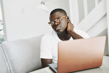 Fototapeta premium man african appearance at home in front of laptop work