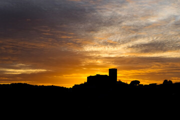 Silhouette of the village and castle of Mértola at sunset, Portugal. Amazing sunset with clouds giving texture to the photo. Alentejo.