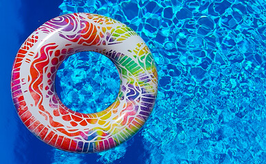 Colored float in a blue pool. Pool float to cool off the hot summer. Summer vibes.