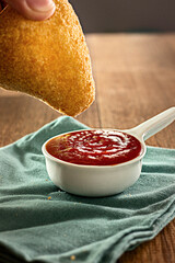 Coxinha - Typical Brazilian Snack with ketchup on a wooden table
