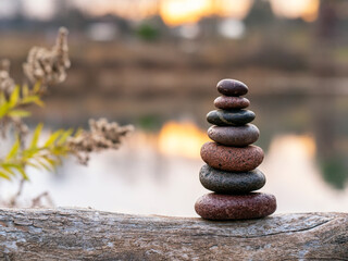 Obraz na płótnie Canvas Zen stones in front of pond at sunset.