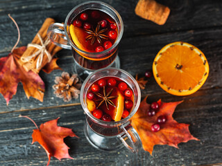Two glasses of autumn mulled wine. Alcoholic spicy drink made of red wine, orange, cinnamon,...