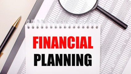 Desktop magnifier, reports, pen and notebook with text FINANCIAL PLANNING. Business concept