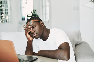 Fototapeta premium man african appearance at home in front of laptop working online