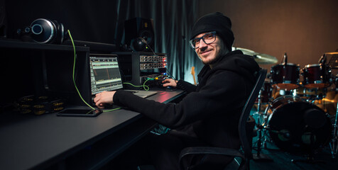 An audio engineer uses a software on laptop to make tracks. Music creation in a recording studio.