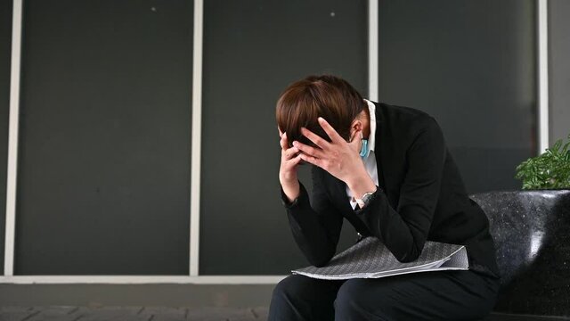 Unemployed businesswoman stressed after failure and laid off from work because impact from covid-19 pandemic outbreak and economic depression.