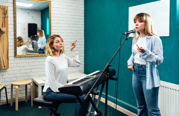 Vocal teacher showing her student how to sing